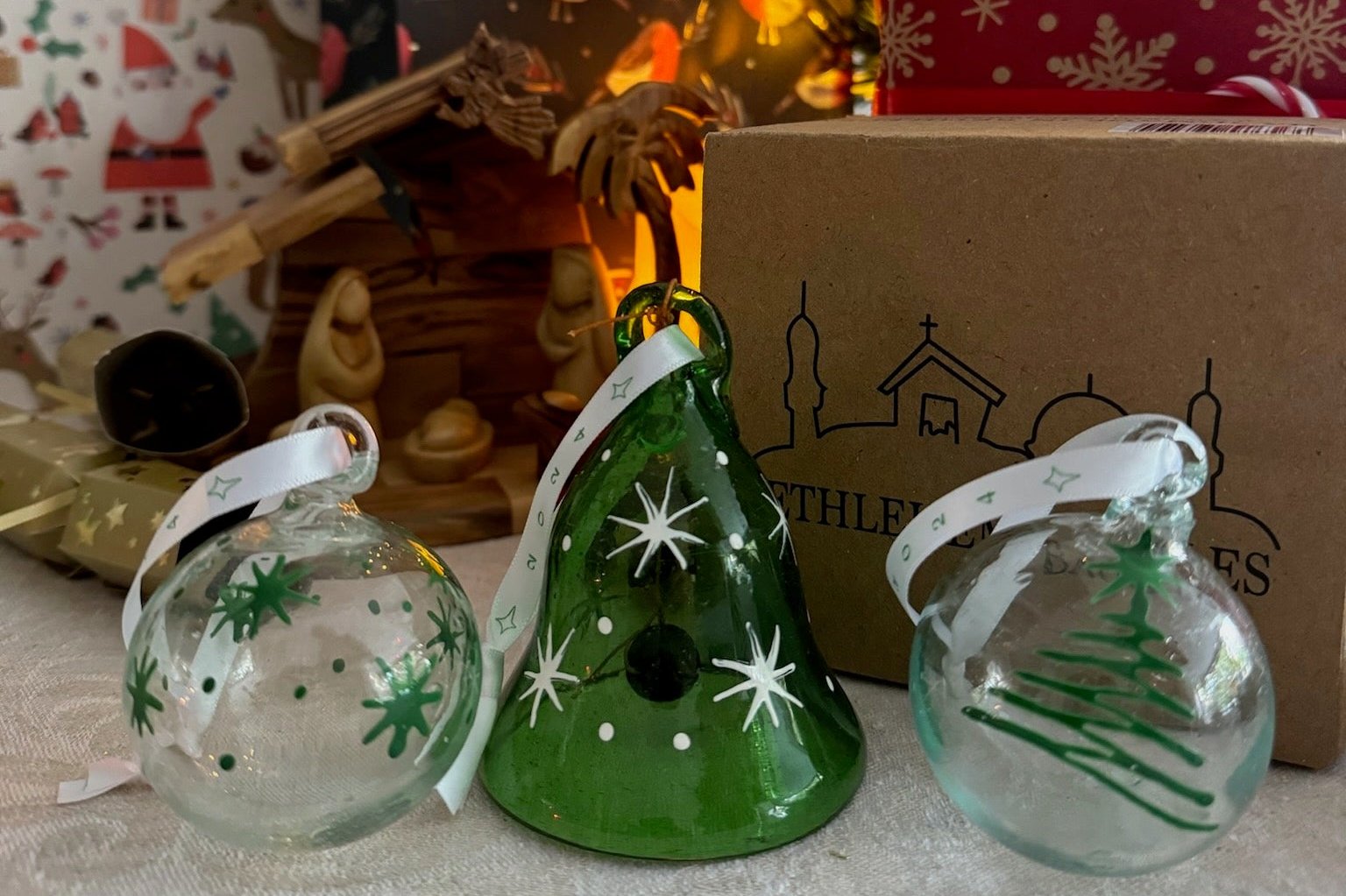 Christmas decorations handmade in Bethlehem from recycled glass featuring bell and two baubles.