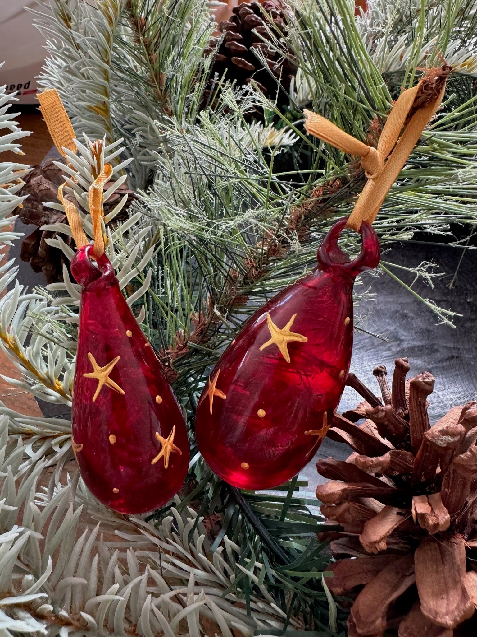 Mini glass Christmas baubles painted with gold stars and hanging on gold ribbon.  handmade in Bethlehem