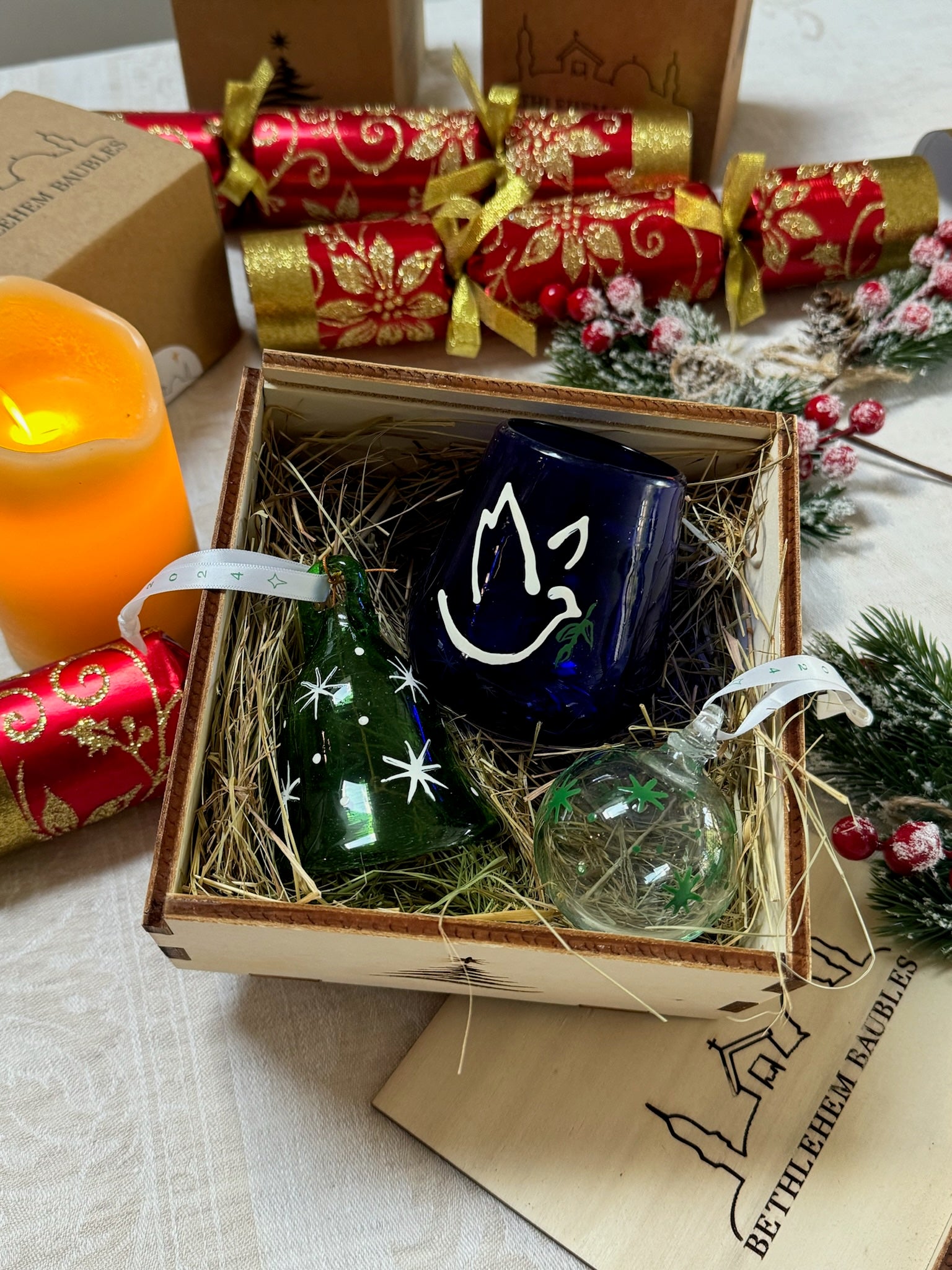 Christmas, gift box with dark blue glass peace light, clear bauble green stars, green glass bell white stars. nesting in wooden box. handmade in Bethlehem