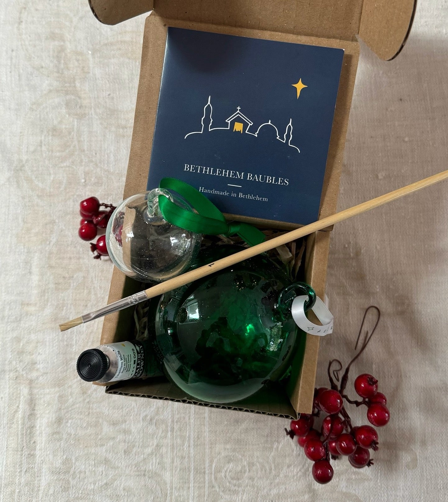 Paint your own hand-blown green glass bauble with a (plain) white ribbon attached for hanging. Made in Bethlehem